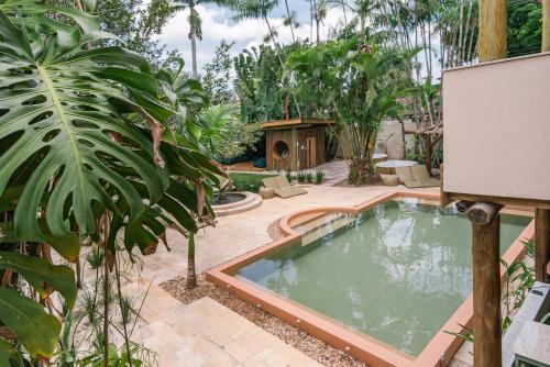 una piscina en un jardín con plantas en Pousada Pazuu en Ubatuba