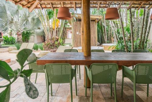una mesa y sillas en un patio con palmeras en Pousada Pazuu en Ubatuba