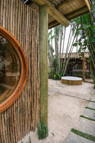 a wooden fence with a round mirror on it at Pousada Pazuu in Ubatuba