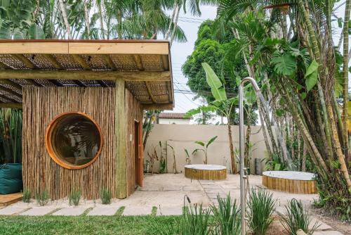 a building with a round window and two benches at Pousada Pazuu in Ubatuba