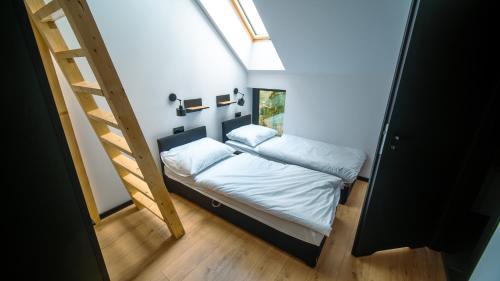 a small bedroom with a bed and a ladder at Willa Perła Jezior in Mrągowo