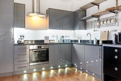 a kitchen with stainless steel appliances and black cabinets at Urban Elegance - 2 Bed Luxury City Retreat in Nottingham