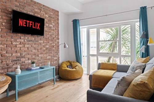 a living room with a couch and a brick wall at Urban Elegance - 2 Bed Luxury City Retreat in Nottingham