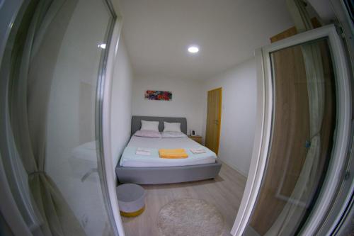 a small bedroom with a bed and a shower at UKROPINA APARTMENTS in Trebinje