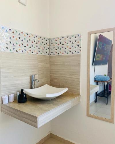 a bathroom with a sink and a mirror at Alojamiento tres pinos in Yelateni