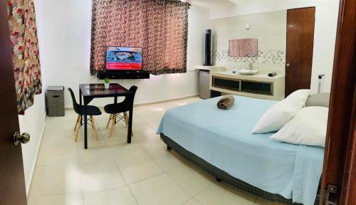 a bedroom with a bed and a table and a television at Alojamiento tres pinos in Yelateni