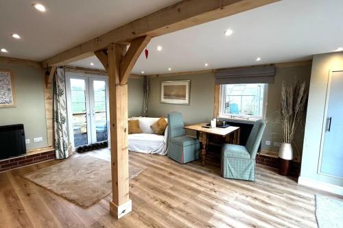 a living room with a bed and a table and chairs at The Old Workshop - a cosy country retreat in Gloucester
