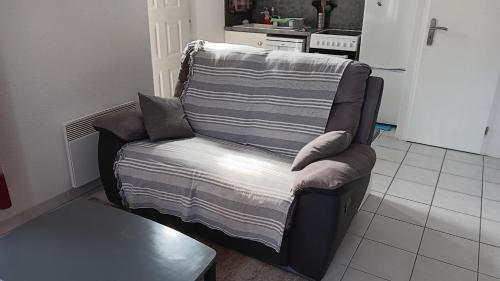 Maison de vacances à quelques pas des remparts في إج مورت: أريكة عليها بطانية في غرفة المعيشة