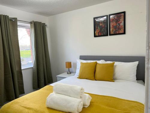 a bedroom with a bed with yellow and white pillows at Perculiar Homes in Birmingham