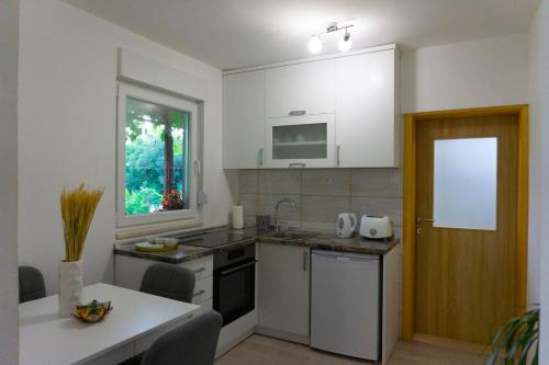 a kitchen with a sink and a stove top oven at UKROPINA APARTMENTS in Trebinje