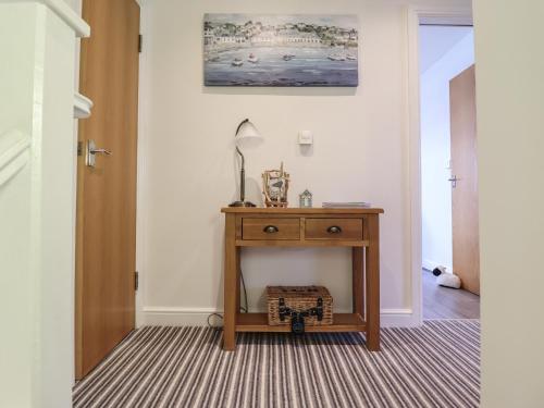 a hallway with a table with a lamp on it at Harbour View in Porthmadog