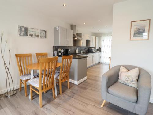 a kitchen and dining room with a table and chairs at Harbour View in Porthmadog