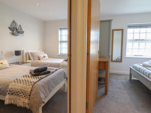 een slaapkamer met 2 bedden en een spiegel bij Harbour View in Porthmadog