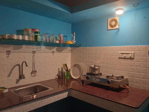 a kitchen counter with a sink and a stove at Lake Homes in Varkala