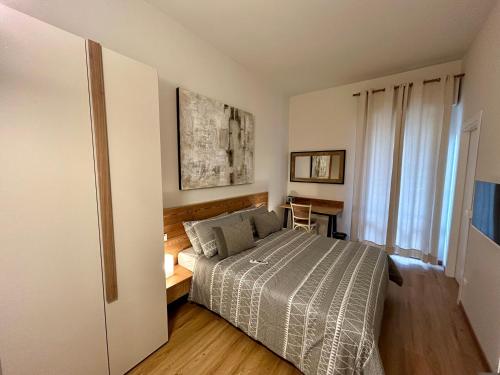 a bedroom with a bed and a table and a window at UNODUE House in Cuneo