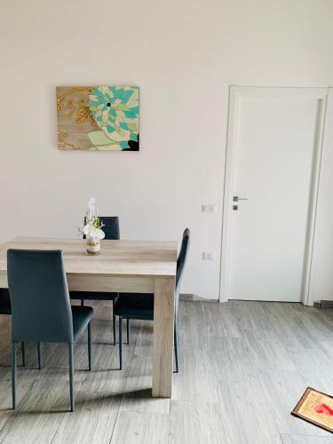 a dining room table with chairs and a painting on the wall at Luce in Serramanna