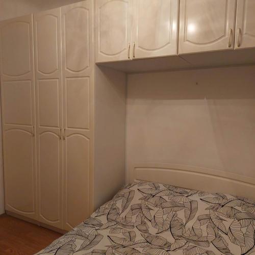 - une chambre avec un lit et des armoires blanches dans l'établissement 2-кімнатна квартира, à Varsovie
