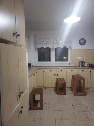- une cuisine avec des placards et des tabourets en bois dans l'établissement 2-кімнатна квартира, à Varsovie