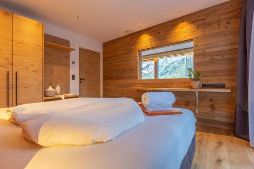 een slaapkamer met een groot wit bed en een raam bij Chalet Panorama Himmelreich in San Candido