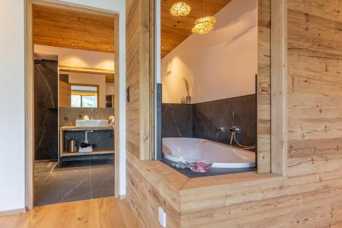 een badkamer met een bad en een wastafel bij Chalet Panorama Himmelreich in San Candido