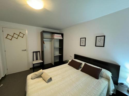 a bedroom with a large bed with brown pillows at APARTAMENTO ROMELIA bajo A in Tivenys