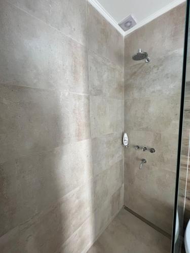 La salle de bains est pourvue d'une douche avec une porte en verre. dans l'établissement TERRA - Departamento 2, à Esperanza