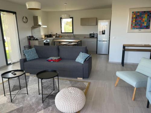 un salon avec un canapé et une cuisine dans l'établissement VILLA LOUNA, à Lecci