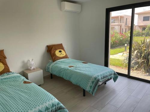 une chambre avec deux lits jumeaux et une fenêtre dans l'établissement VILLA LOUNA, à Lecci