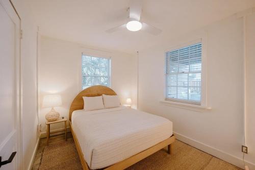 a white bedroom with a bed and a window at The Bungalow Lounge by WB Abodes in Wrightsville Beach