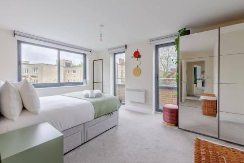 a bedroom with a bed and a large window at Modern & Bright 2 Bed with Pvt Balcony in Islington in London