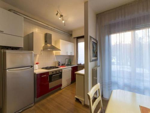 una cucina con elettrodomestici rossi e bianchi e un tavolo di Solaris Apartment with swimming pool a Lazise