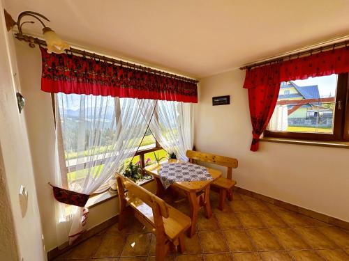 a dining room with a table and a window at Dom Gościnny Granit in Biały Dunajec