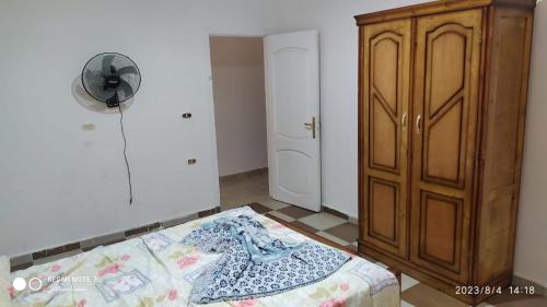 a bedroom with a bed and a wooden cabinet at Luxry flat in matrouh in Marsa Matruh