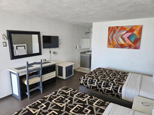 Cette chambre comprend deux lits, un bureau et un miroir. dans l'établissement LaVid Aguascalientes, à Aguascalientes