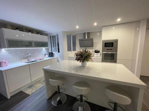 a kitchen with a large white island with bar stools at Increíble piso céntrico in Gandía