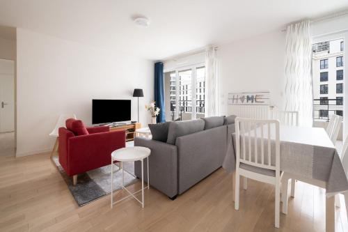 a living room with a couch and a table at Bright T4 with balcony in Saint-Ouen - Welkeys in Saint-Ouen