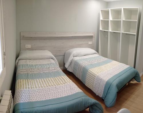 two beds sitting next to each other in a bedroom at A orillas del Duero in Soria