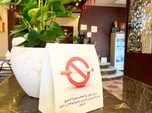 a sign with a no smoking sign on a table at البندقية للخدمات الفندقية BQ HOTEL SUITES in Buraydah