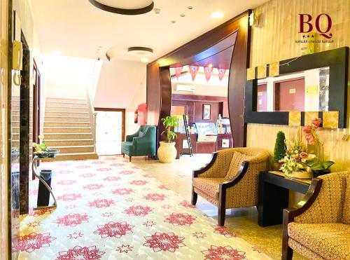a lobby with two chairs and a staircase in a building at البندقية للخدمات الفندقية BQ HOTEL SUITES in Buraydah