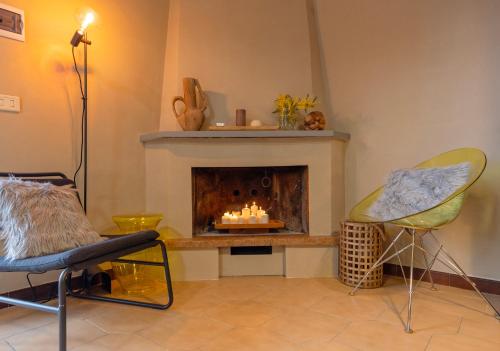 a living room with a fireplace and two chairs at Vicolo Zenone 8 Casa Esclusiva tra Natura e Arte in Garzano