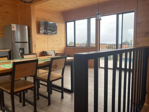 a kitchen with a table with chairs and a refrigerator at Twin Brothers Pichidangui 1 in Pichidangui