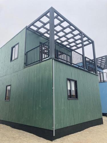 a green building with a balcony on top of it at Twin Brothers Pichidangui 1 in Pichidangui