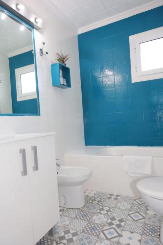 a bathroom with a white toilet and a blue wall at Hotel Marazul in Mojácar
