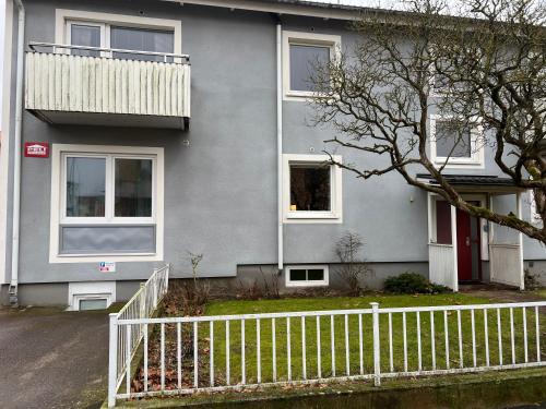 a gray house with a white fence in front of it at Central, university - centralt, högskolan in Halmstad