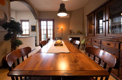a dining room with a wooden table and chairs at Vicolo Zenone 8 Casa Esclusiva tra Natura e Arte in Garzano