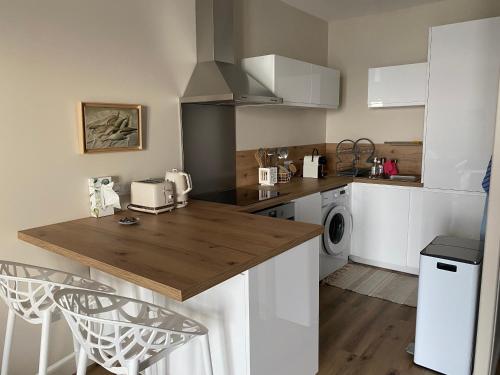 une cuisine avec des armoires blanches et un comptoir dans l'établissement Les balcons de Bouzigues, à Bouzigues