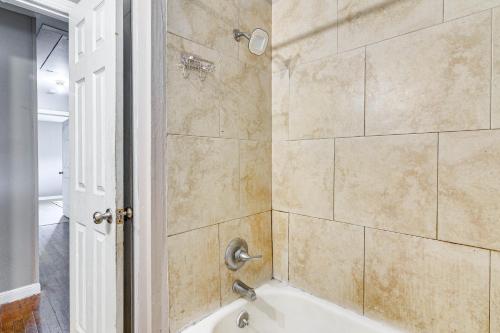 a bathroom with a tub and a shower stall at Spacious Orange Rental about 3 Mi to Museums and Garden! in Orange
