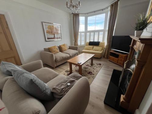 ein Wohnzimmer mit Couch und Tisch in der Unterkunft Spacious first floor family flat, Sea view in Torquay