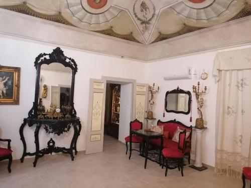 Cette chambre comprend un miroir, une table et des chaises. dans l'établissement Dimora Storica, à Petrignano