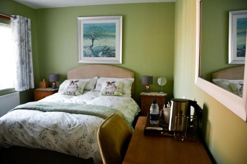 Dormitorio verde con cama y mesa en Meadowsweet House, en Stockton-on-Tees